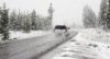 Bil körandes längs en vintrig landsväg