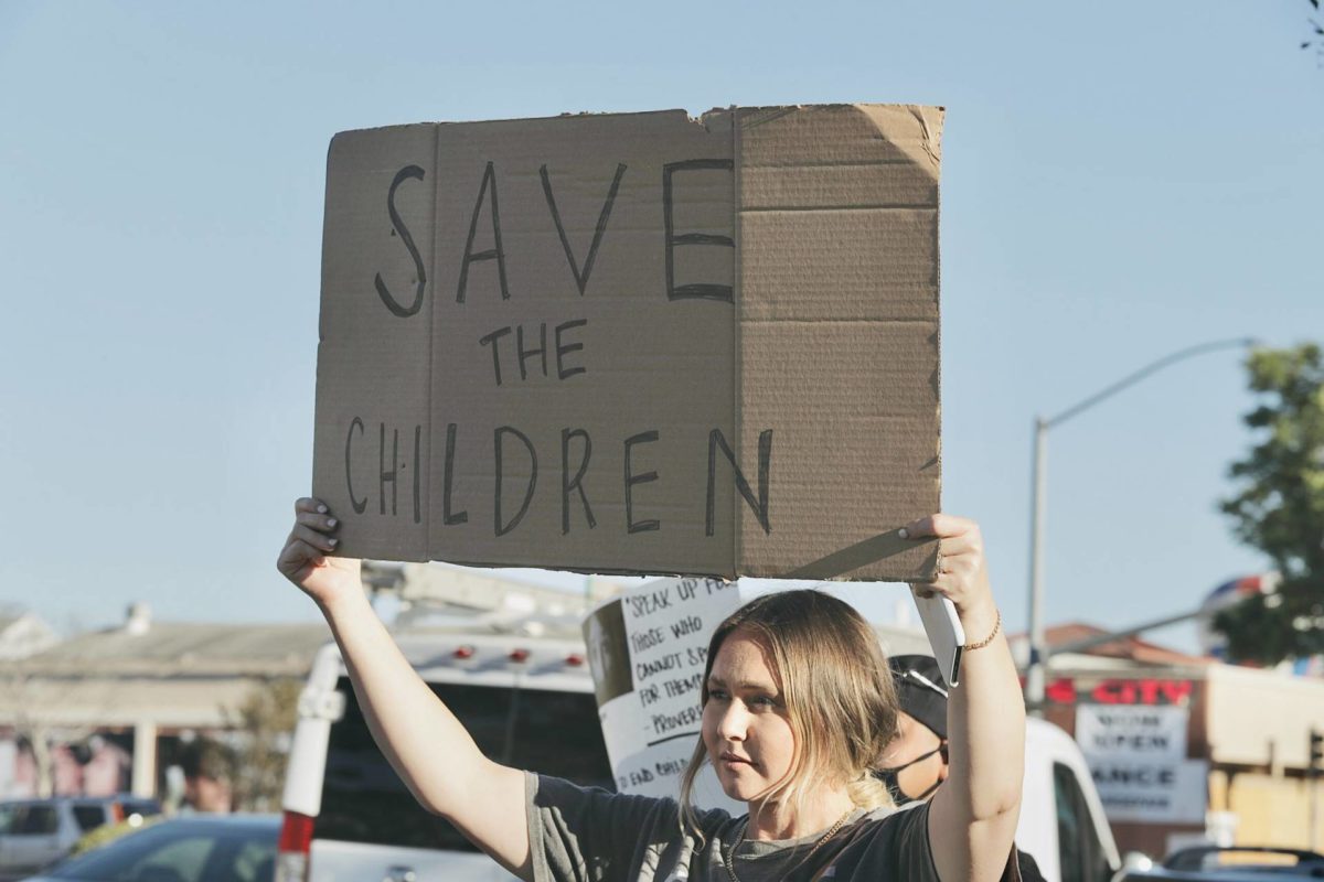 Kvinna med plakat med texten: Save the children