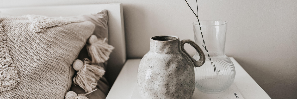 En vas och en kruka på ett nattduksbord