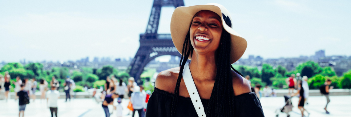 Glad turist framför Eiffeltornet i Paris