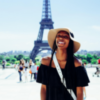 Glad turist framför Eiffeltornet i Paris