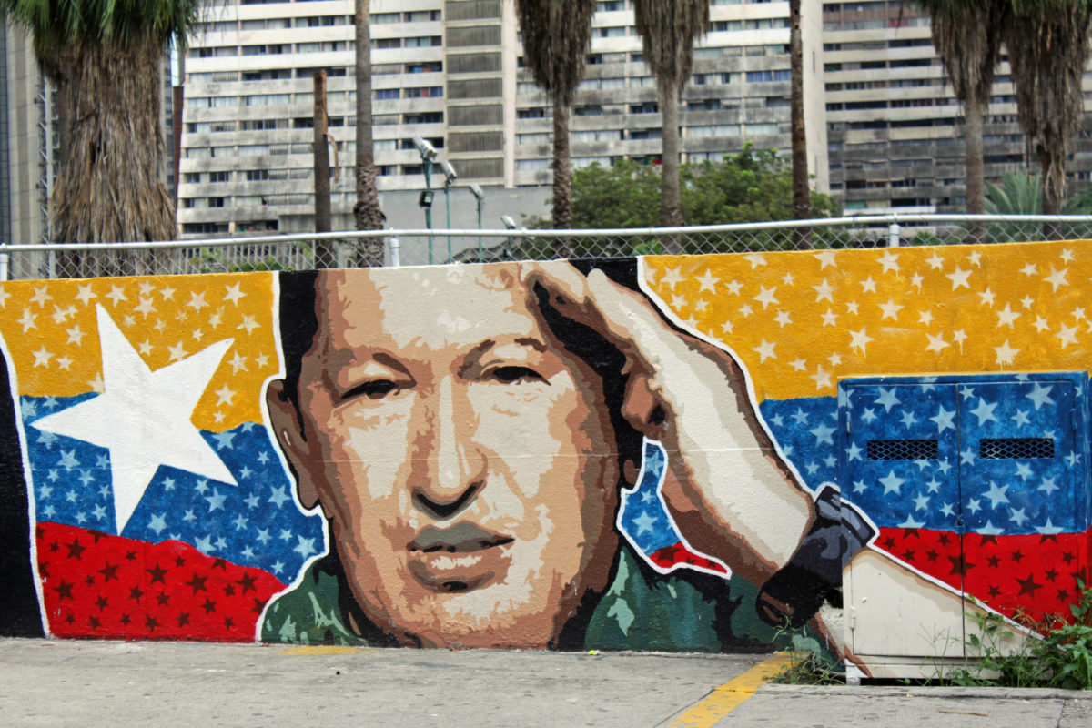 Väggmålning av Hugo Chávez framför slitna höghus