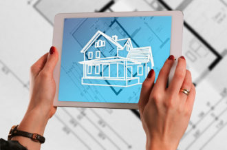 En kvinnas händer som håller i en husritning