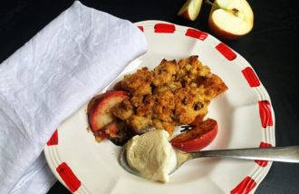 En tallrik med nybakad äppelpaj med en skopa glass